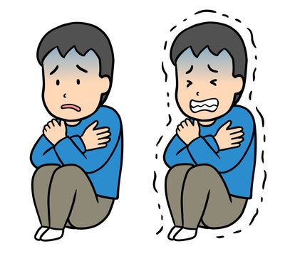 体調不良や寒さで体育座りをして青ざめて震える男性