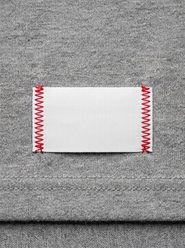 Blank White Clothing Label Mockup with Red Zigzag Stitching on Gray Heathered Fabric