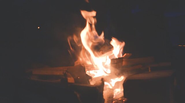 Burning campfire with stacked wood at night