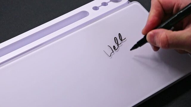 European male hand writing well done on whiteboard with black pen and erases it with white sponge afterwards for seamless looping message writing on whiteboard. Positive feedback message from boss.