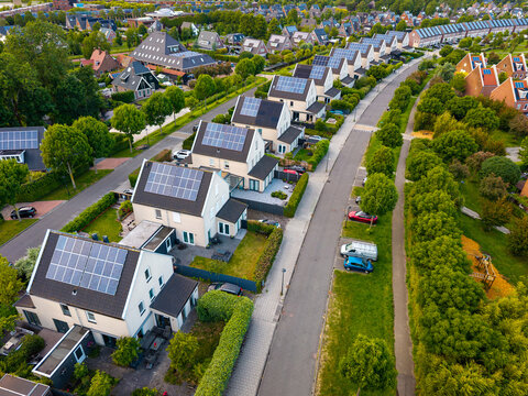 Aerial view of modern residential houses with solar panels on their roofs in stad van de zon city district in Heerhugowaard, North Holland, Netherlands.