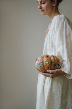 Close-Up View Of Woman Holding Unique Hand Painted Pumpkin With Colorful Floral Motifs
