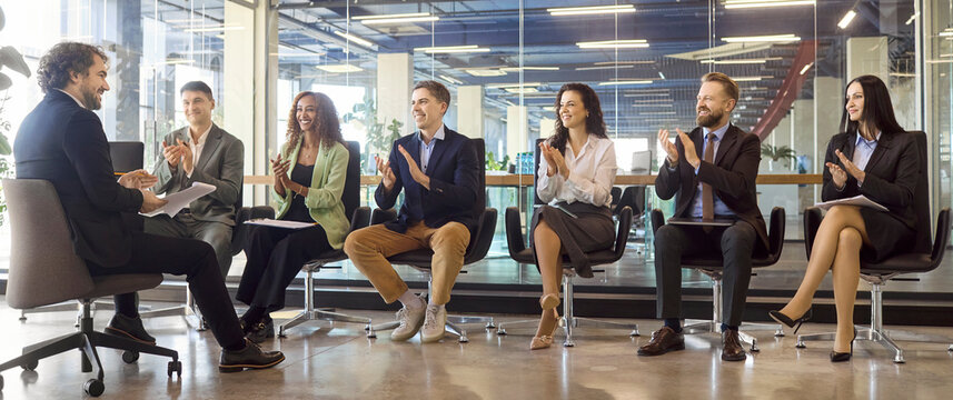 Business audience applauding speaker as team coworkers. A diverse group in an office claps during a workshop, showing motivation and leadership. Concept highlights corporate training success.