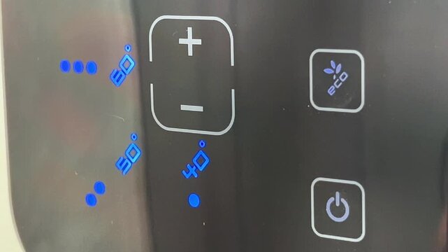 Extreme close up shot of a finger pressing the eco mode button on a sleek electronic digital touch control display panel. Energy saving concept.