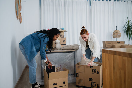 Couple packing boxes together during home relocation