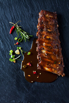 Marinated and grilled spare ribs with Barbecue sauce on slate