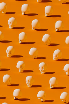 A white cartoon skull pattern covers an orange background