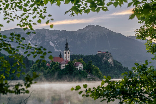 Mist surrounds the pilgrimage church on Lake Bled island at dawn