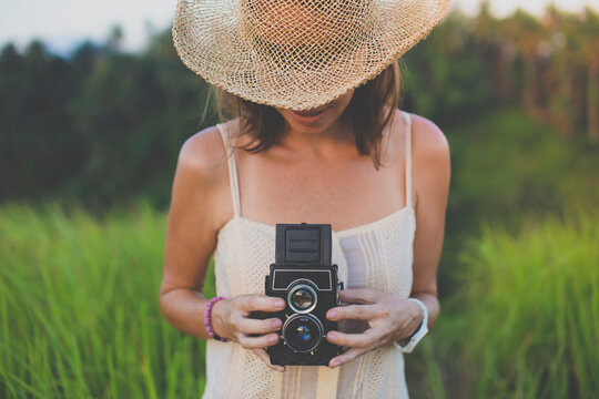 Woman with old camera in fields