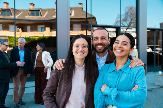 A business team shows a friendly smile outside an office building