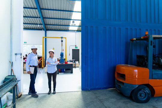 A male and female technician stand at the wind farm workshop entrance