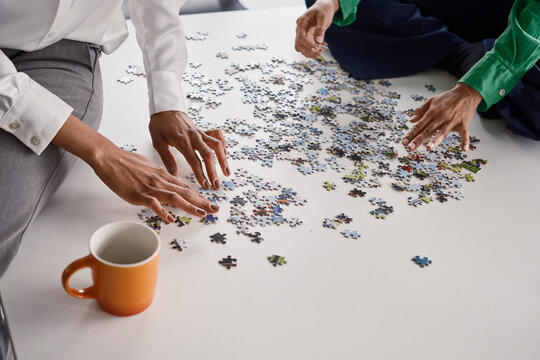 Business colleagues assemble a jigsaw puzzle in the office