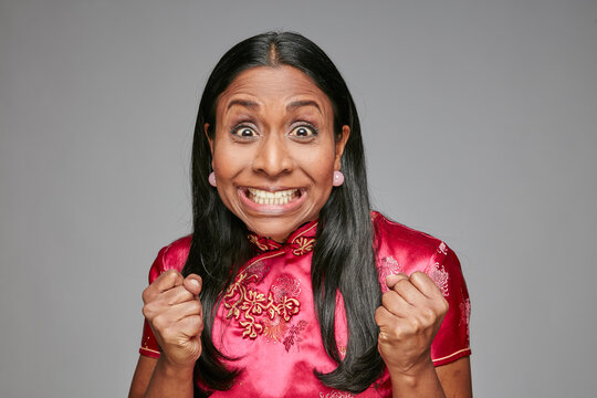 Portrait of woman pulling funny faces while keeping fingers crossed