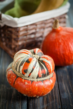 Turban pumpkin and Hokkaido pumpkin on dark wood