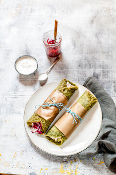 Bombay or Mumbai Frankie Roll, indian streetfood, spinach paratha, indian flatbread with spiced smashed potatoes, red cabbage and carrot relish, yogurt sauce