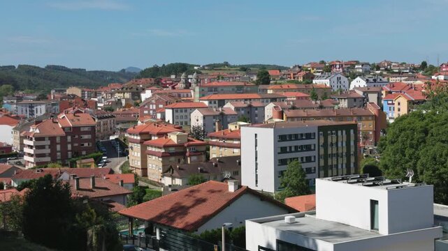 Candas town skyline red roofs green hills background Asturias Spain