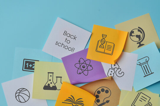 Educational cards with symbols representing various school subjects on a blue background symbolize learning and the season of returning to school.