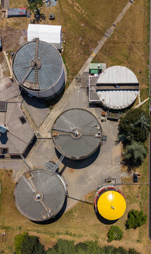 Aerial view of Depuratore di Peschiera Borromeo showing circular wastewater treatment tanks and industrial infrastructure in Peschiera Borromeo, Lombardia, Italy.