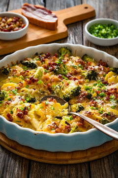 Potato broccoli casserole - baked potatoes with broccoli, cheddar cheese and smoked bacon on wooden table
