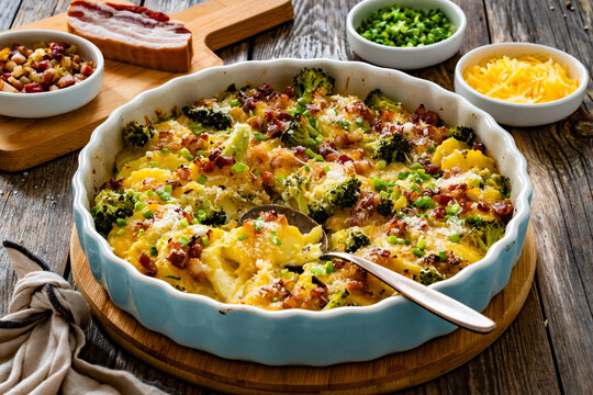 Potato broccoli casserole - baked potatoes with broccoli, cheddar cheese and smoked bacon on wooden table
