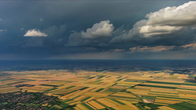 Agricultural fields under dramatic dark storm clouds