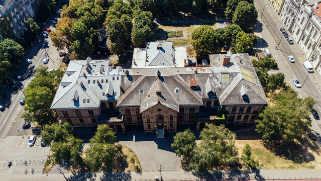 Aerial view of the historic Croatian State Archives building surrounded by lush green trees and urban streets in Zagreb, Croatia.