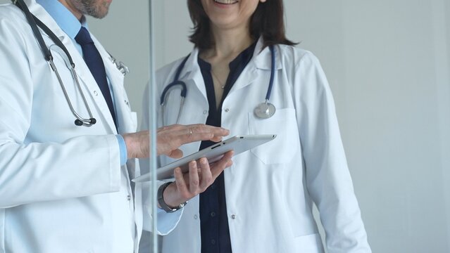 Medical professionals collaborating on patient data research, analyzing health information using a digital tablet for healthcare technology innovations and modern clinical solutions