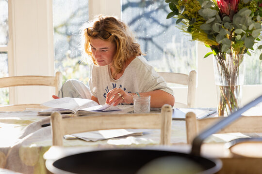 young woman studying at home in light filled room