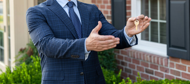 Real estate agent showing house for sale. Property insurance. Real estate market. Broker man. House insurance. Realtor offering new home. Realtor in suit hold key outdoor. Handshake and deal