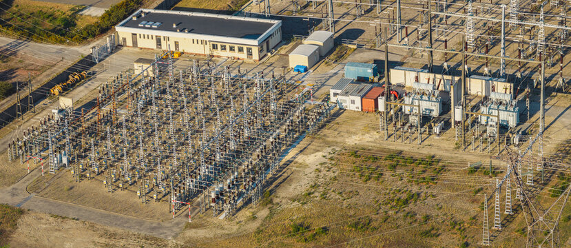 Aerial view of a high voltage electrical substation with transformers, insulators, and transmission infrastructure in Saulce-sur-Rhone, Auvergne-Rhone-Alpes, France.