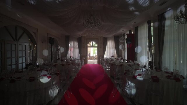 Elegant banquet hall with red carpet aisle and dynamic spotlight bokeh effects, with banquet, hall, carpet, aisle detail, showing table, linen napkin, glassware context