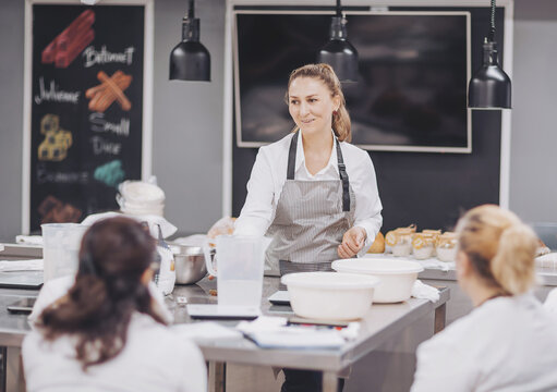 Baking artisan bread in a bright, inviting kitchen with a skilled baker guiding eager students