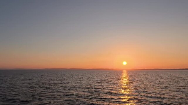 Healing real-time wide angle video of golden sunrise reflection on ocean for relaxation, meditation, and calm mood