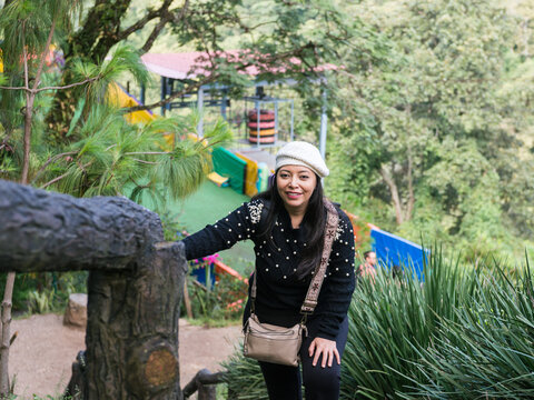 Woman Smiling at Camera While Climbing Stairs in a Natural Park