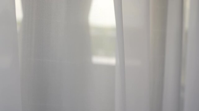 Sheer white curtains parting under soft daylight with gentle billow and layered vertical panels, with curtain, sheer, fabric, white detail, showing panel, gap,drape, fold context