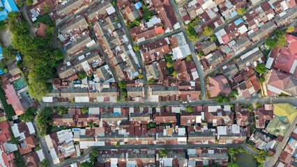 Dense urban settlement with rusty metal rooftops seen from a high aerial perspective during the day