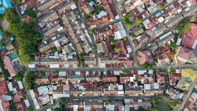 Dense urban settlement with rusty metal rooftops seen from a high aerial perspective during the day