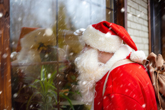 Santa Claus looks in the window. He brings a sack of presents.