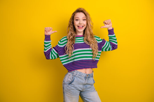 Young woman in striped sweater smiles against yellow background promoting casual fashion lifestyle