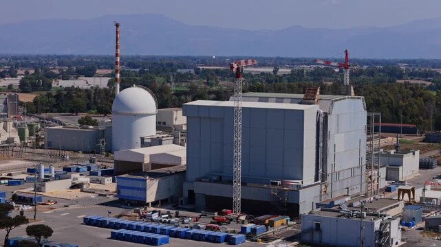 Aerial view of a nuclear power plant showing the reactor containment building, turbines hall, and surrounding industrial infrastructure