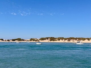 view from the Playa de Sancti Petri over the Cano de Sancti Petri with boats to the dunes of Playa de Camposoto, vacation, Chiclana de la Frontera, Cadiz, Andalusia, Spain © keBu.Medien