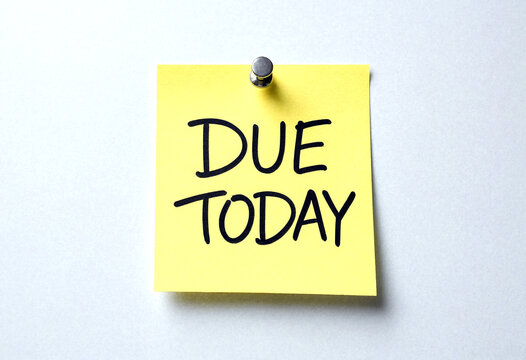 Bright yellow sticky note with due today written in bold handwriting pinned to surface