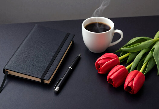 Flat lay composition with notebook pen coffee and red tulips on dark table perfect for inspiration and creativity