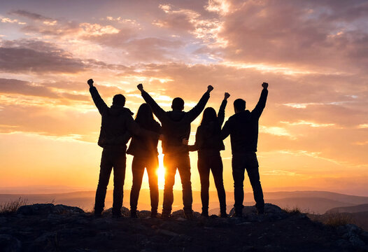 Group of friends standing together with raised arms celebrating success at sunset in nature