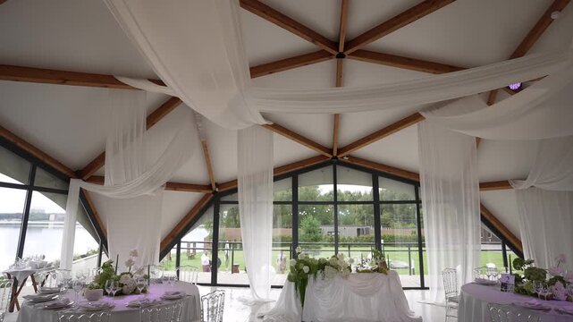 Vaulted wooden truss ceiling with sheer fabric drapery over waterfront reception space, with ceiling, truss, wood, drape detail, showing, fabric, window, glass context