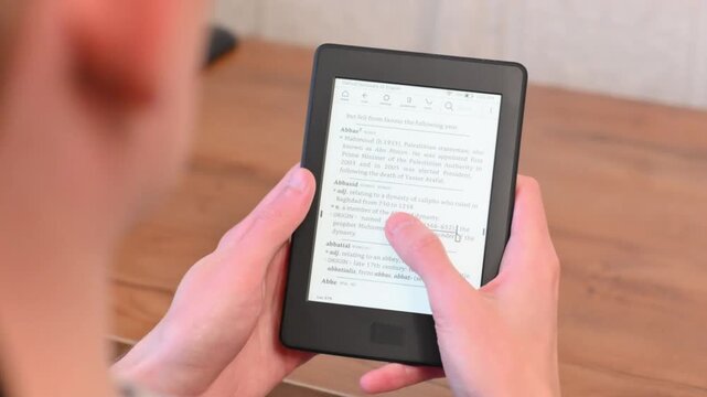 Casual home moment with electronic book held over wooden surface