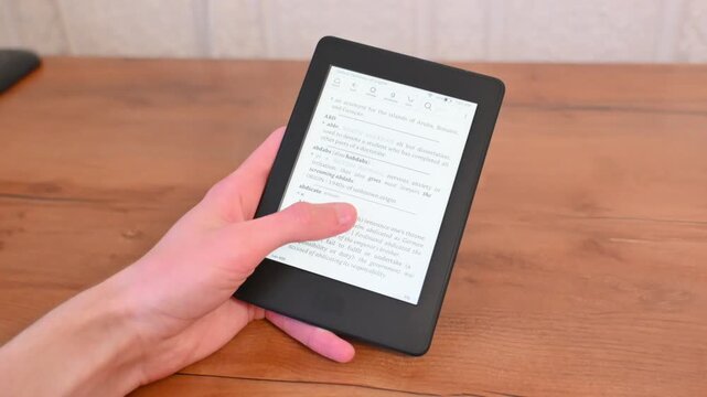 Casual home moment with electronic book held over wooden surface