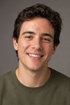 Smiling young man with acne in soft window light