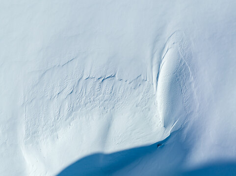 Aerial view of wind-swept snow patterns on a mountain slope in Valldal, More og Romsdal, Norway.