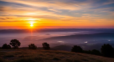 Obraz premium Golden sunrise over misty mountain valley landscape at dawn